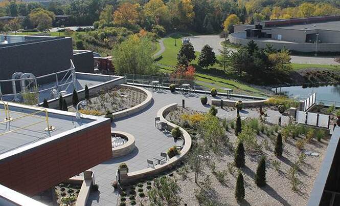 An overhead picture featuring the custom green roof system installed by Paul Crandall & Associates for the ProHealth Care hospital. The picture features a walkway, benches, garden, and a fountain. 