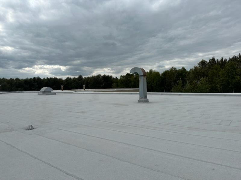 Gray modified bitumen commercial roofing system on CertainTeed plant in L'Anse Michigan. Features a variety of vents including plumbing and exhaust | Paul Crandall and Associates Inc. 