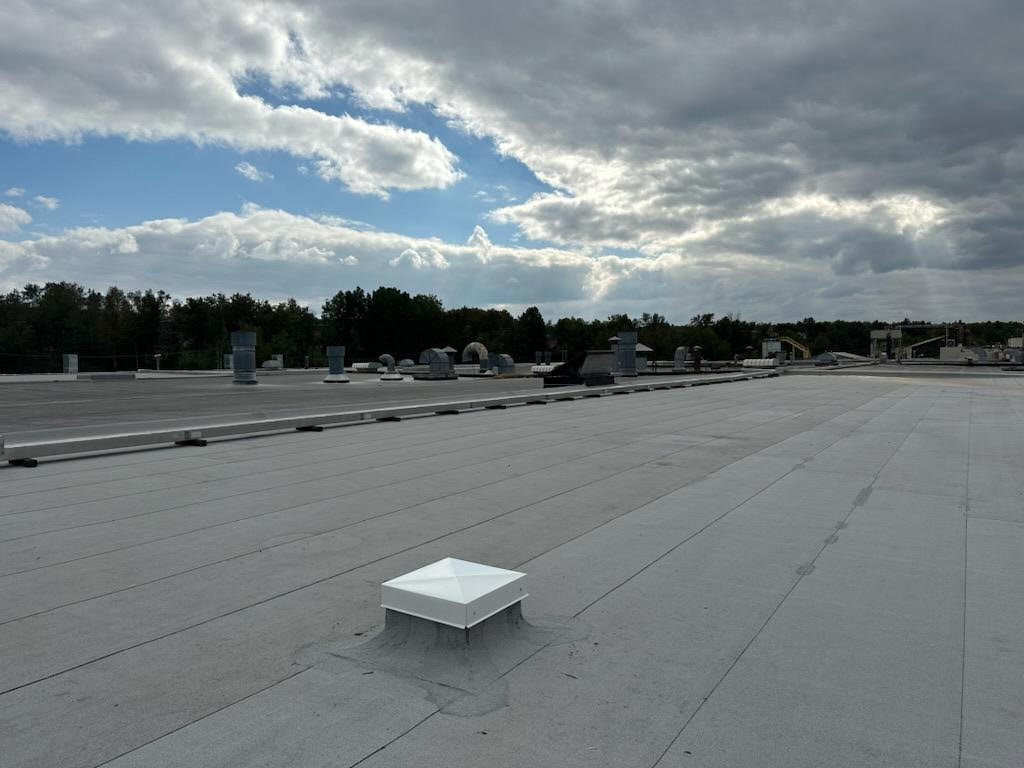 gray modified bitumen commercial roofing system on the CertainTeed plant in L'Anse Michigan. Features a variety of  proper flat roof vent systems including, plumbing and exhaust.   | Paul Crandall and Associates 